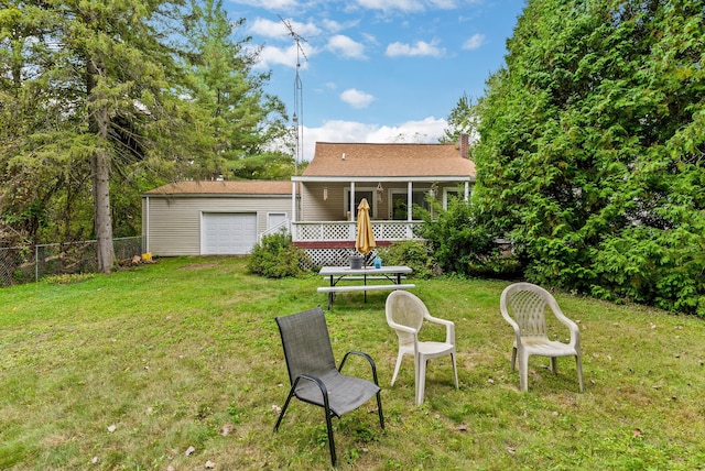 rear view of house featuring a yard, a garage, and a sunroom