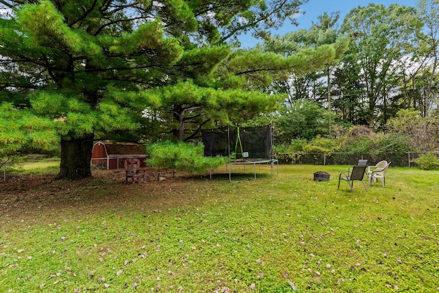 view of yard featuring a fire pit and a trampoline