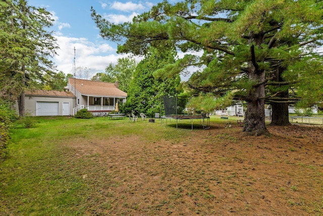 view of yard with a garage and a trampoline