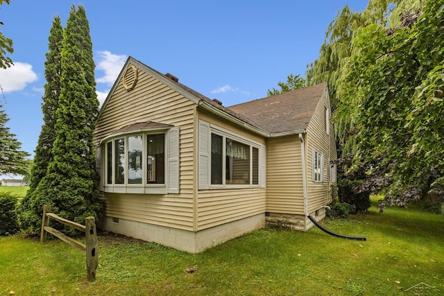 view of side of home with a yard