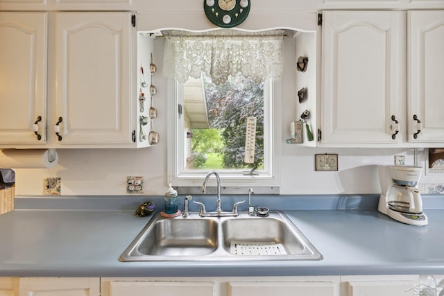 kitchen featuring white cabinetry and sink