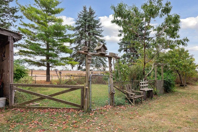 view of gate with a lawn