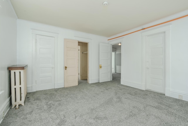 unfurnished bedroom with light colored carpet, ornamental molding, and a closet