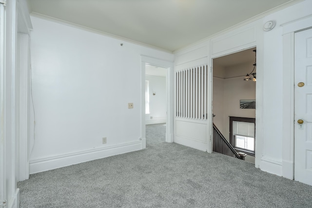 unfurnished bedroom with crown molding, light colored carpet, and a notable chandelier