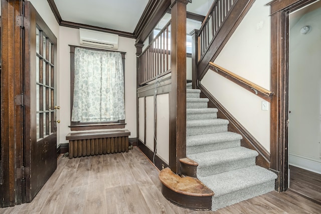 stairway featuring wood-type flooring, an AC wall unit, radiator, and ornamental molding