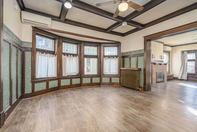 unfurnished sunroom with ceiling fan, beam ceiling, a wall unit AC, and coffered ceiling