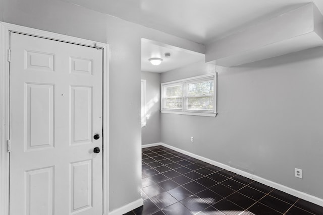 unfurnished room featuring dark tile patterned floors