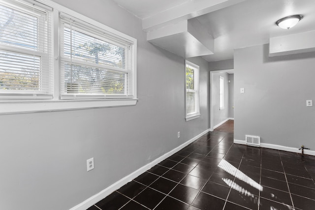 spare room with dark tile patterned flooring