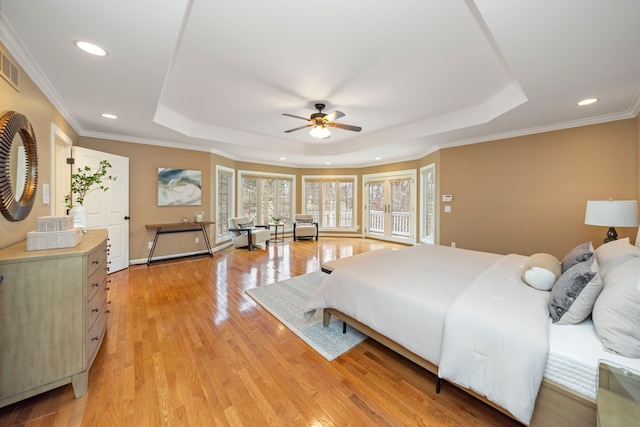 bedroom featuring a raised ceiling, crown molding, ceiling fan, and light wood-type flooring