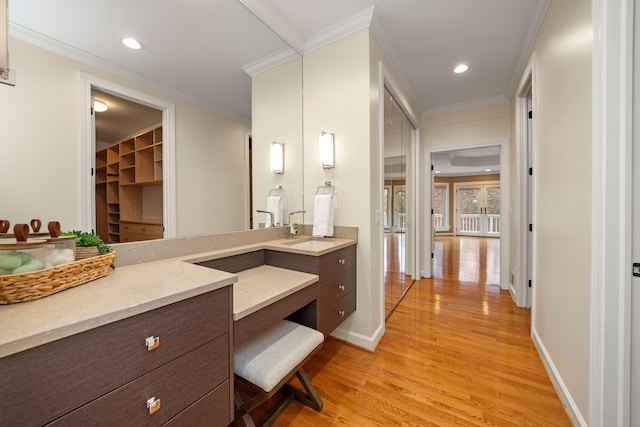 bathroom featuring hardwood / wood-style floors, vanity, and ornamental molding