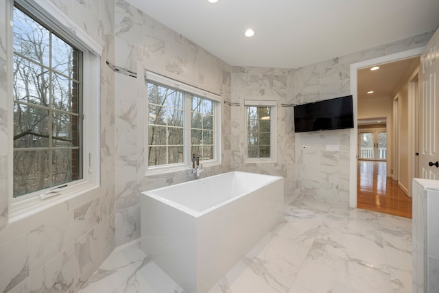 bathroom featuring tile walls and a bathing tub