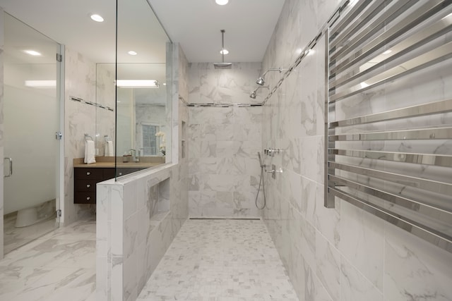 bathroom featuring a tile shower and vanity