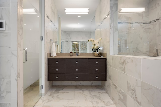 bathroom with vanity, an enclosed shower, and tile walls