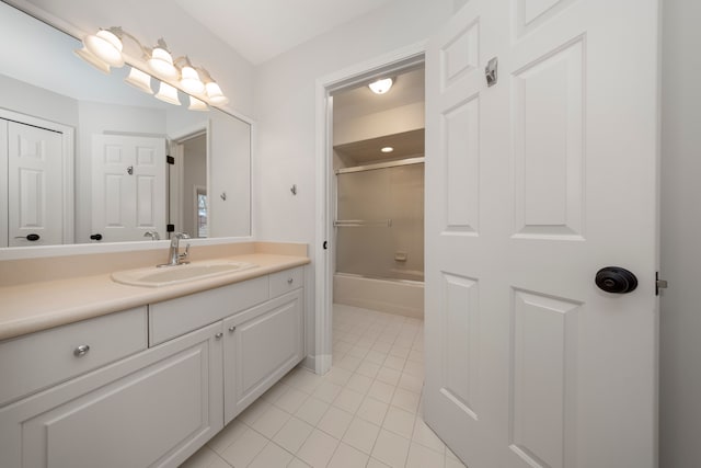 bathroom featuring tile patterned flooring, vanity, and shower / bath combination with glass door