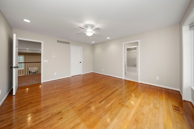 unfurnished bedroom with a closet, ceiling fan, light hardwood / wood-style flooring, and a spacious closet