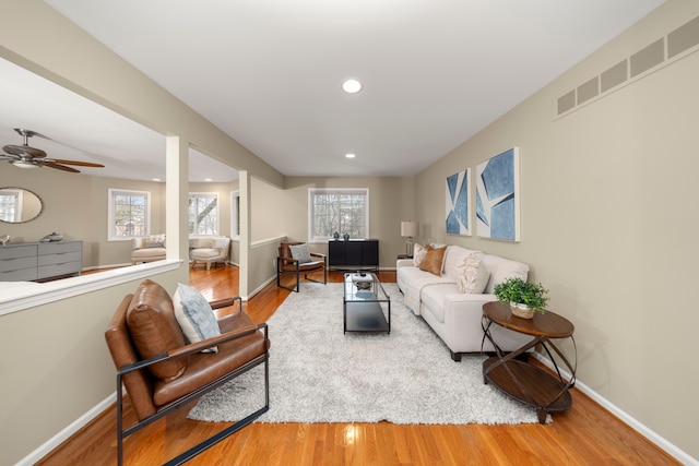 living room with wood-type flooring and ceiling fan