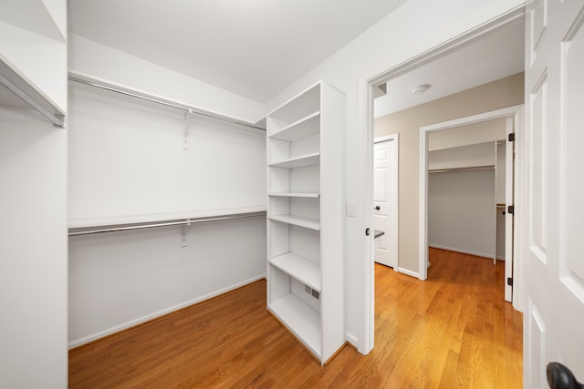 walk in closet with light wood-type flooring