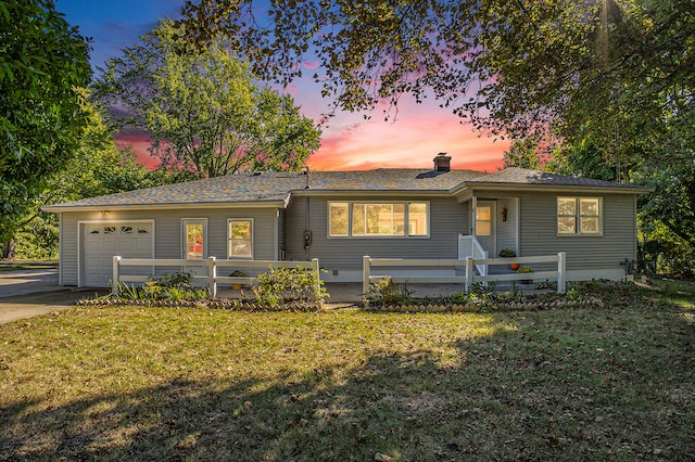 ranch-style house with a yard and a garage