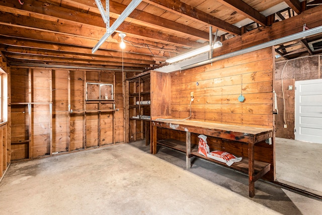 basement featuring a workshop area and wood walls