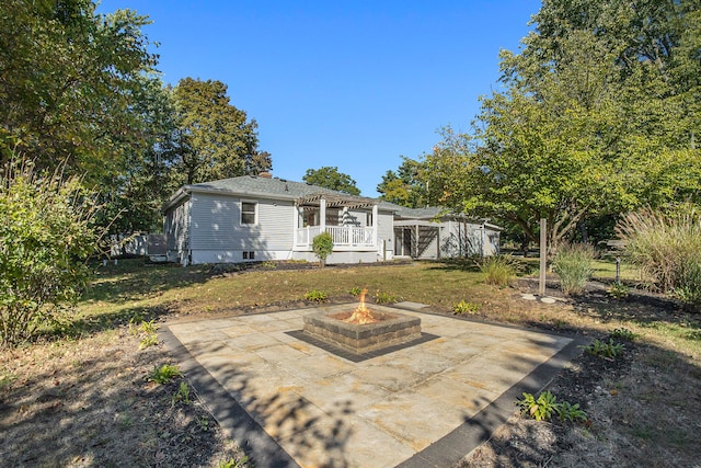 back of house featuring a yard, an outdoor fire pit, and a patio