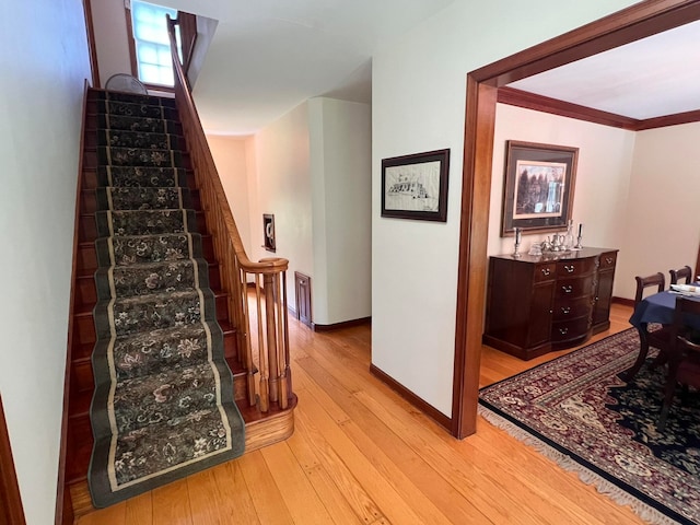 staircase featuring hardwood / wood-style flooring and crown molding