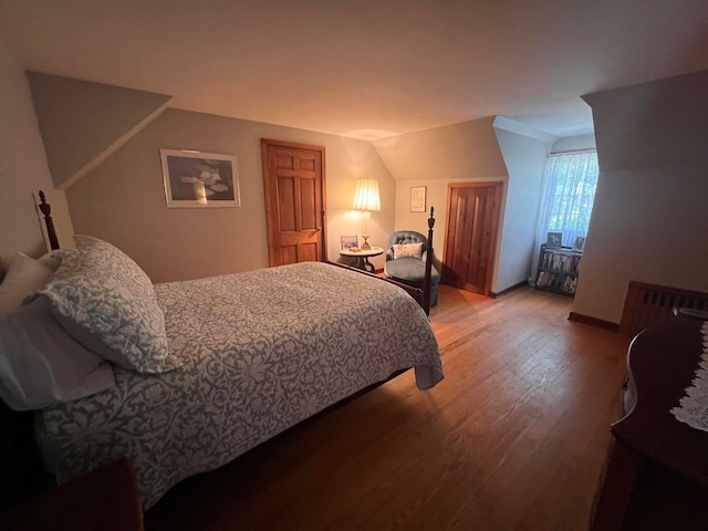 bedroom with hardwood / wood-style floors and vaulted ceiling