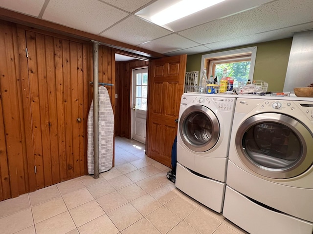 laundry room featuring wood walls, light tile patterned flooring, and independent washer and dryer