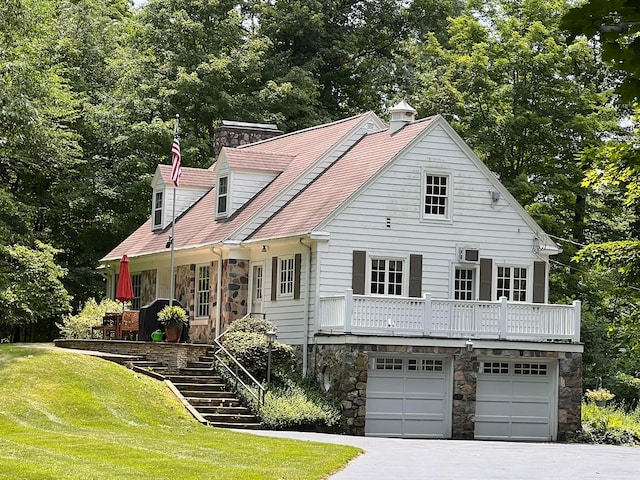 new england style home featuring a front yard and a garage