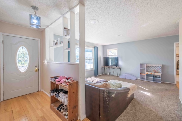 foyer entrance featuring a textured ceiling and light hardwood / wood-style flooring