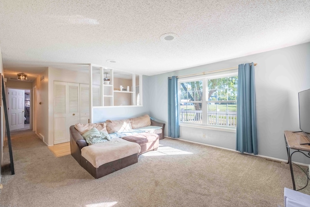 carpeted living room featuring a textured ceiling