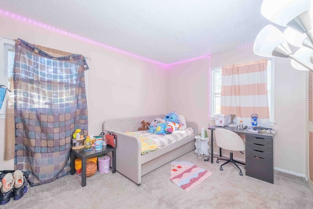 bedroom with light colored carpet and a textured ceiling