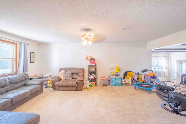 rec room with ceiling fan, carpet floors, and a textured ceiling