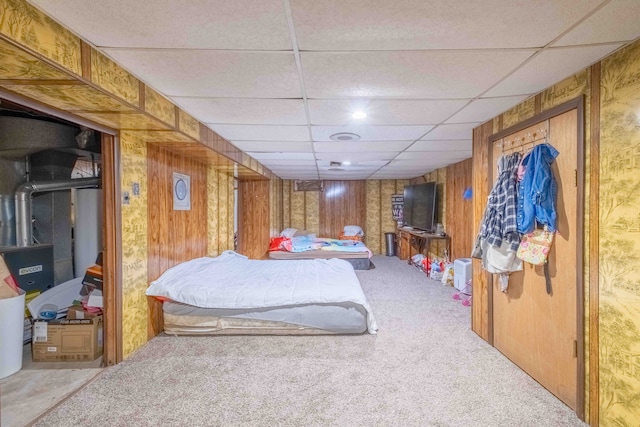 bedroom featuring a paneled ceiling, carpet floors, and wood walls