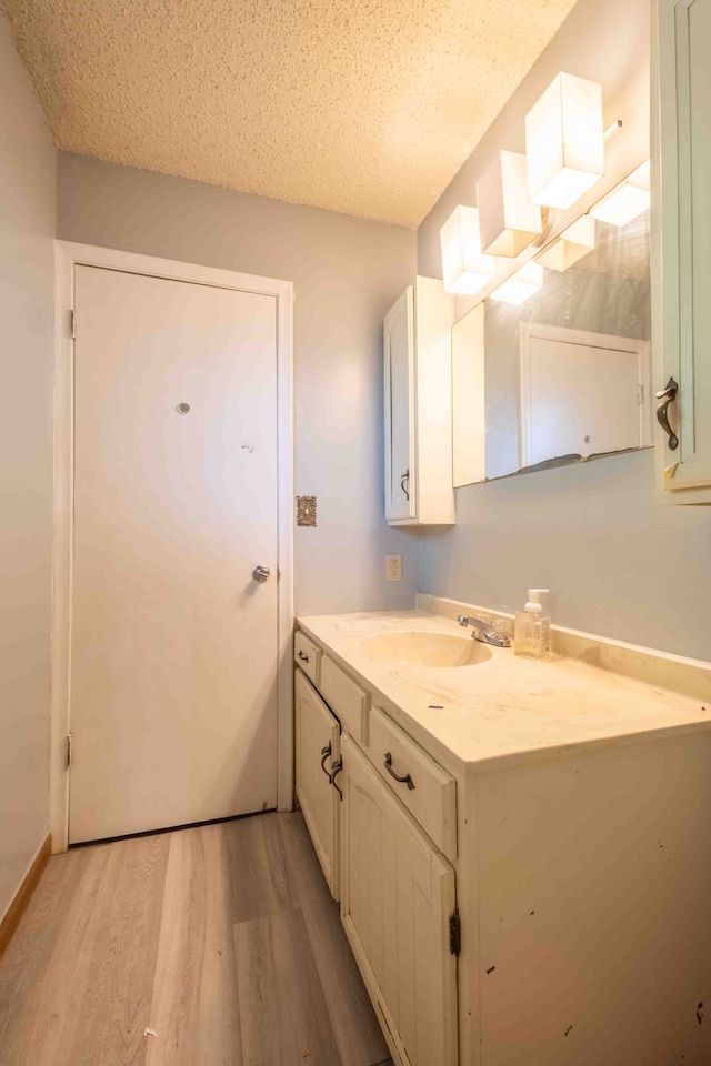 bathroom with vanity, wood-type flooring, and a textured ceiling