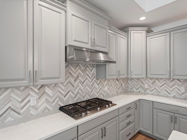 kitchen with gray cabinetry, stainless steel gas stovetop, and tasteful backsplash