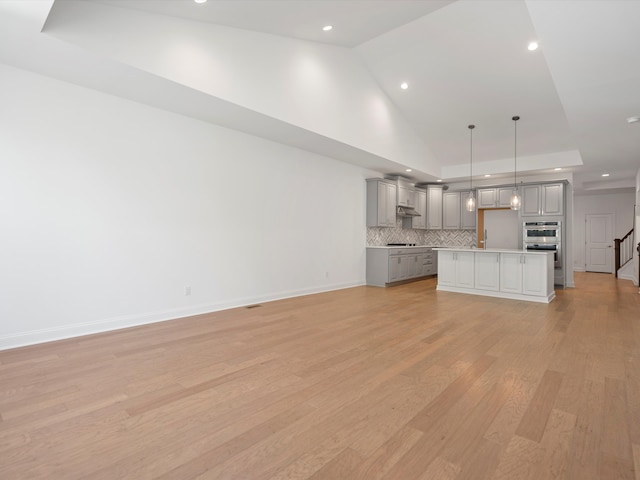 unfurnished living room with light wood-type flooring and vaulted ceiling