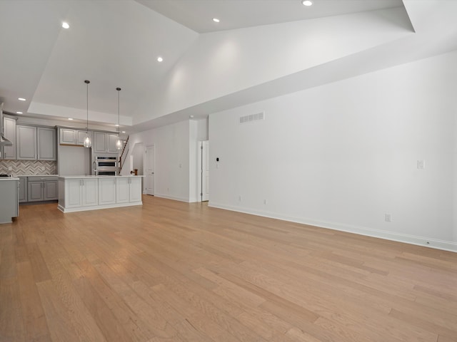 unfurnished living room featuring light hardwood / wood-style flooring and vaulted ceiling