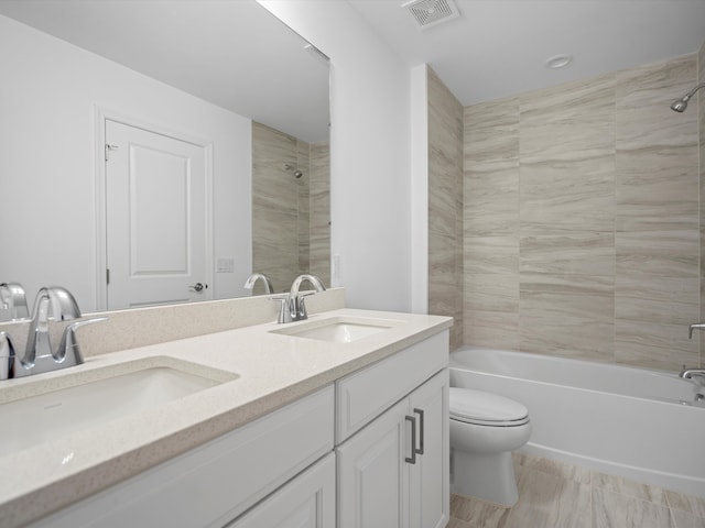 full bathroom featuring vanity, toilet, and tiled shower / bath combo