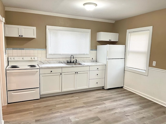 kitchen with white appliances, white cabinets, crown molding, sink, and light wood-type flooring