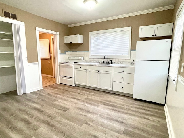 kitchen with white cabinetry, sink, light hardwood / wood-style flooring, white refrigerator, and electric stove