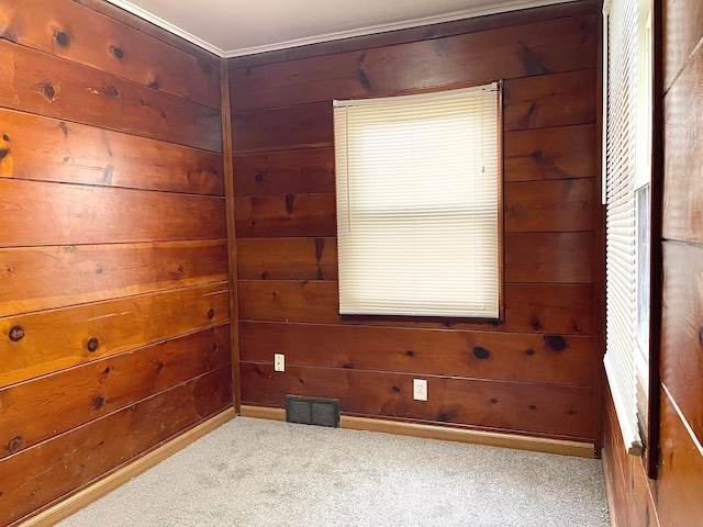 spare room featuring wood walls and light carpet