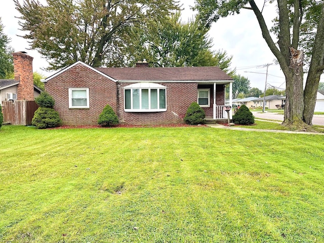 view of front of house with covered porch and a front lawn