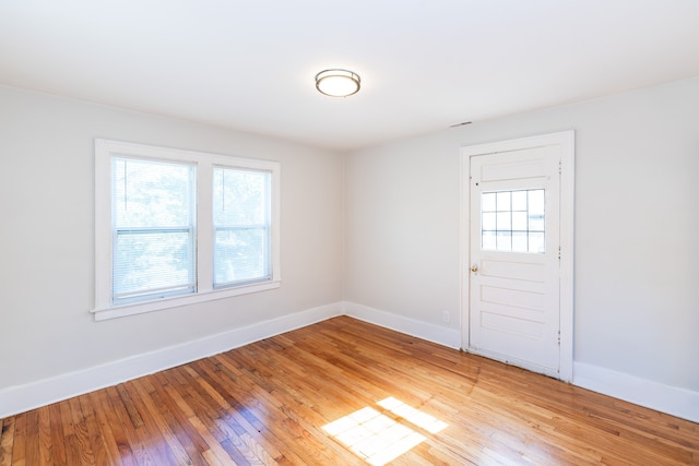 spare room featuring light wood-type flooring and a wealth of natural light