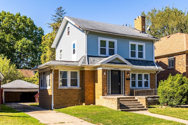 view of front of house with an outbuilding, a garage, and a front yard