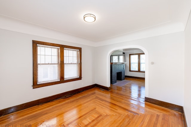 spare room featuring parquet flooring and a fireplace