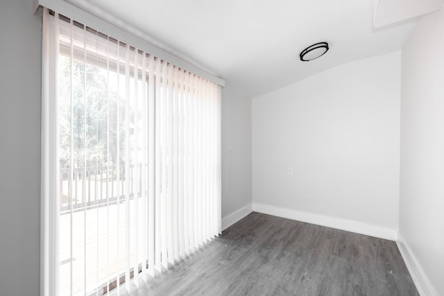 unfurnished room with vaulted ceiling and dark hardwood / wood-style floors