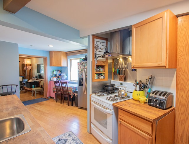 kitchen with decorative backsplash, white range with gas cooktop, stainless steel fridge with ice dispenser, light hardwood / wood-style floors, and range hood