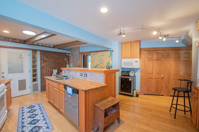 kitchen featuring white appliances, an island with sink, beverage cooler, and light hardwood / wood-style flooring