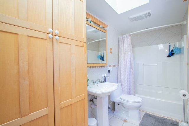 full bathroom featuring a skylight, shower / bathtub combination with curtain, tasteful backsplash, tile patterned floors, and toilet