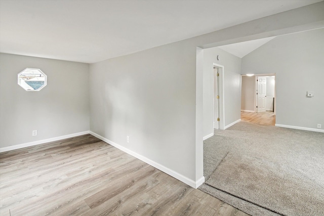 empty room featuring light hardwood / wood-style flooring and lofted ceiling